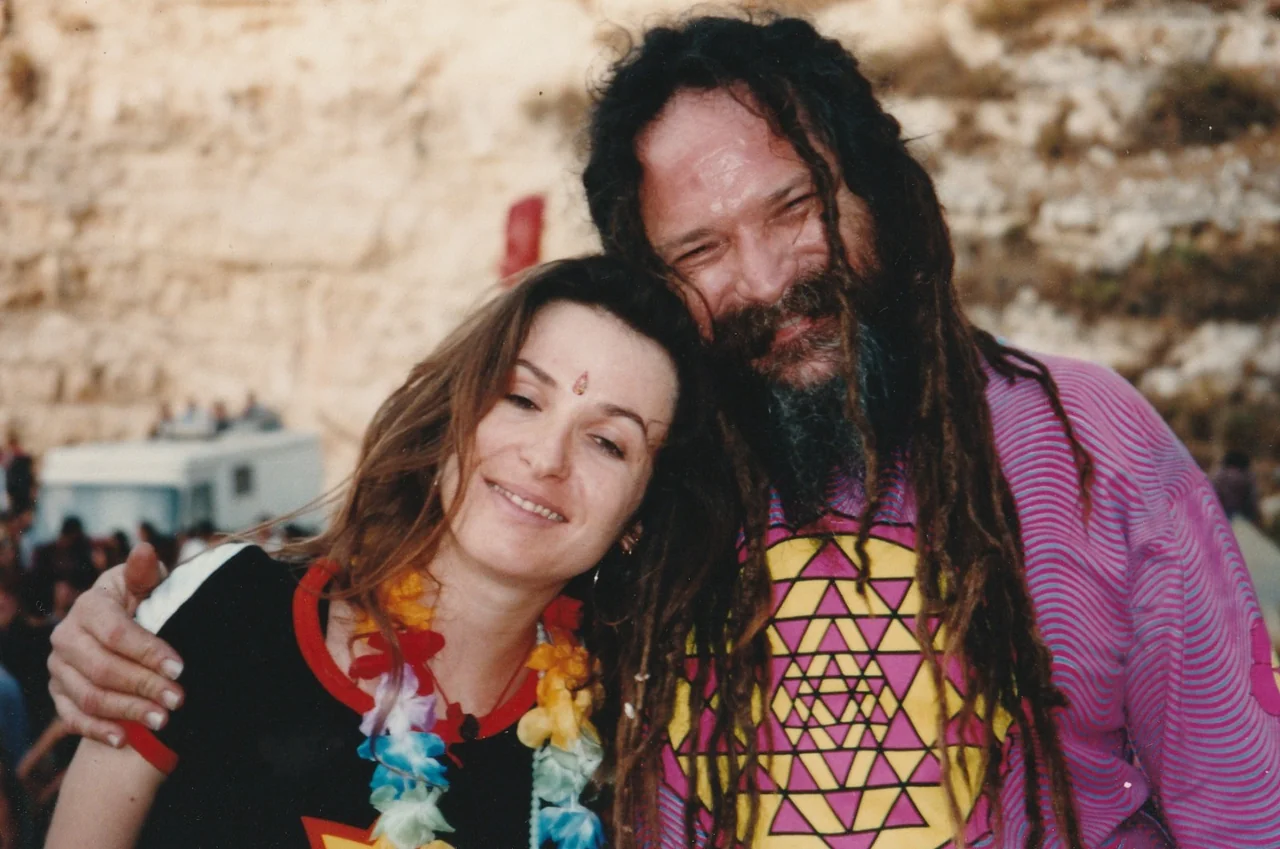 Gil and Ariane together, her head resting on his shoulder, at an outdoor gathering